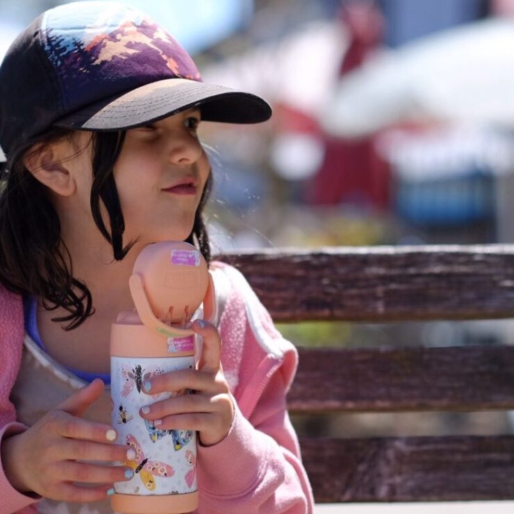 Pige med vandflaske på bænk