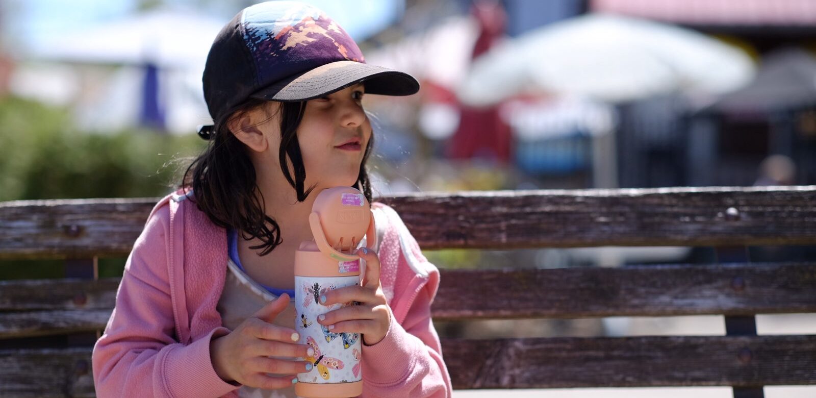 Pige med vandflaske på bænk